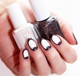Model displaying black and white nail art with matching nail polish